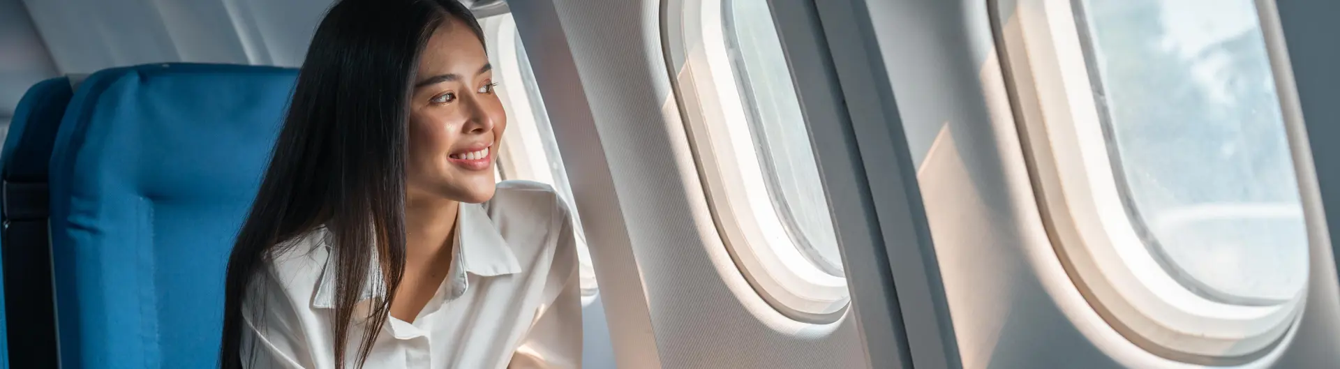 Female business traveller looking out plane window